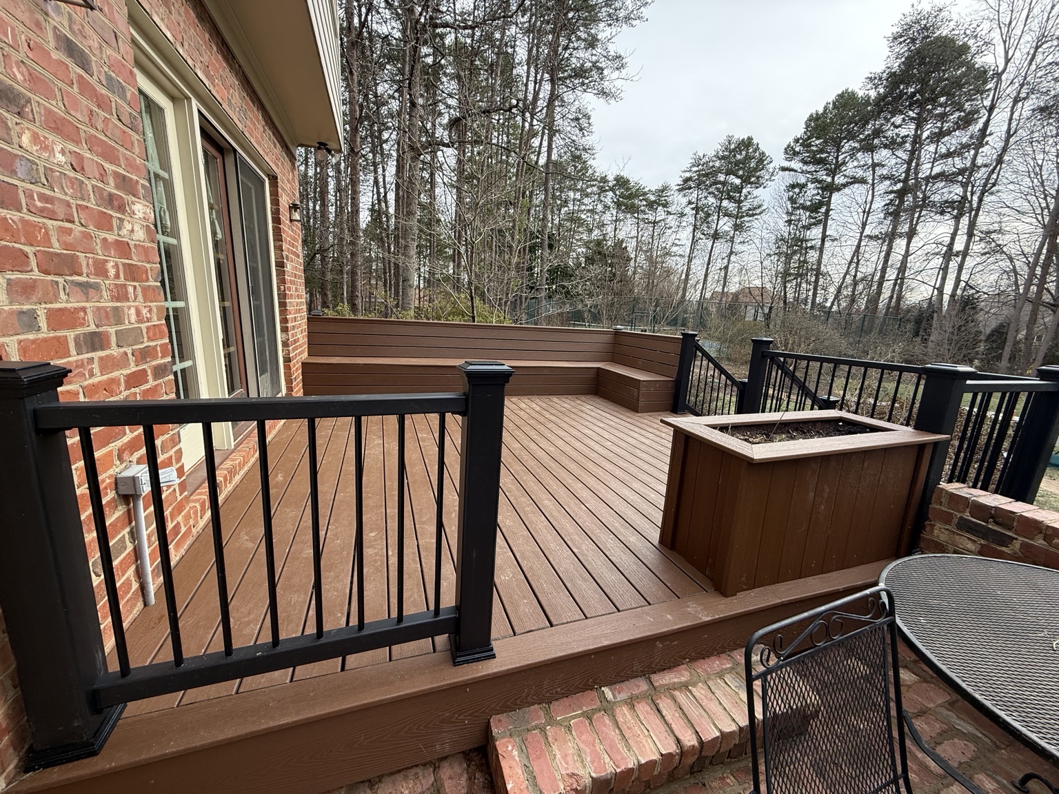 Finished composite deck with benches, privacy wall, and aluminum railing