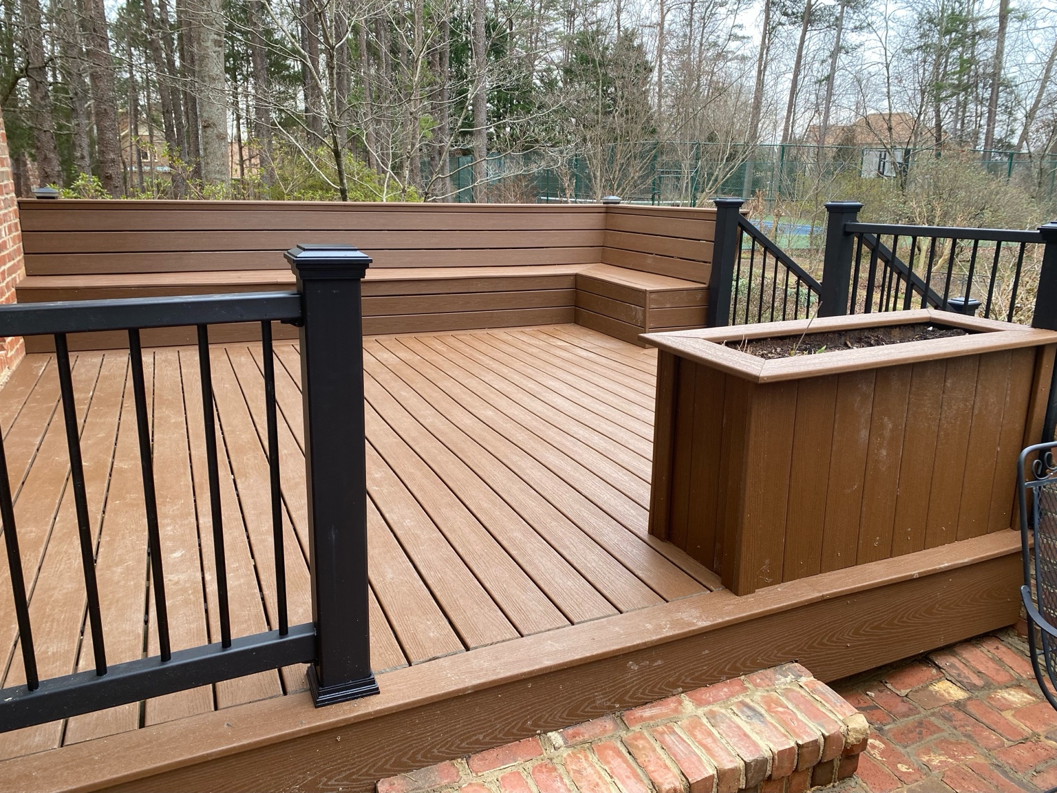 Composite deck with built-in bench seating and black aluminum railing
