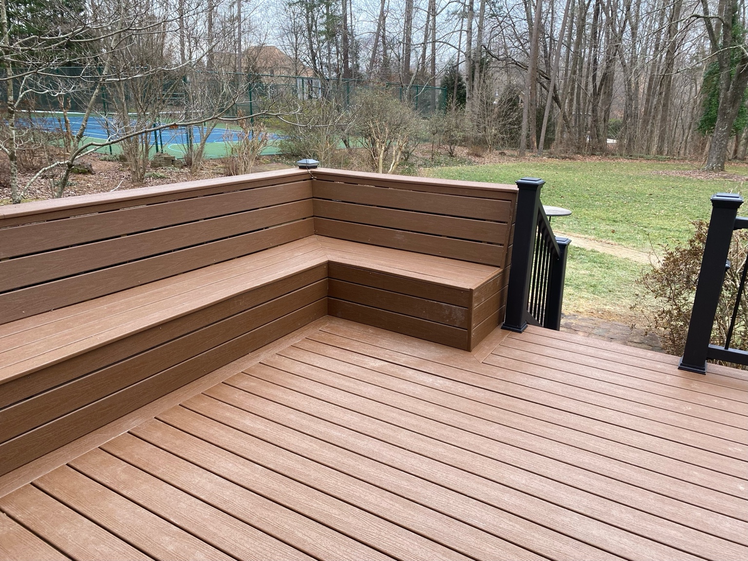 Custom composite deck and built-in bench seating completed by Nailed It Property Management